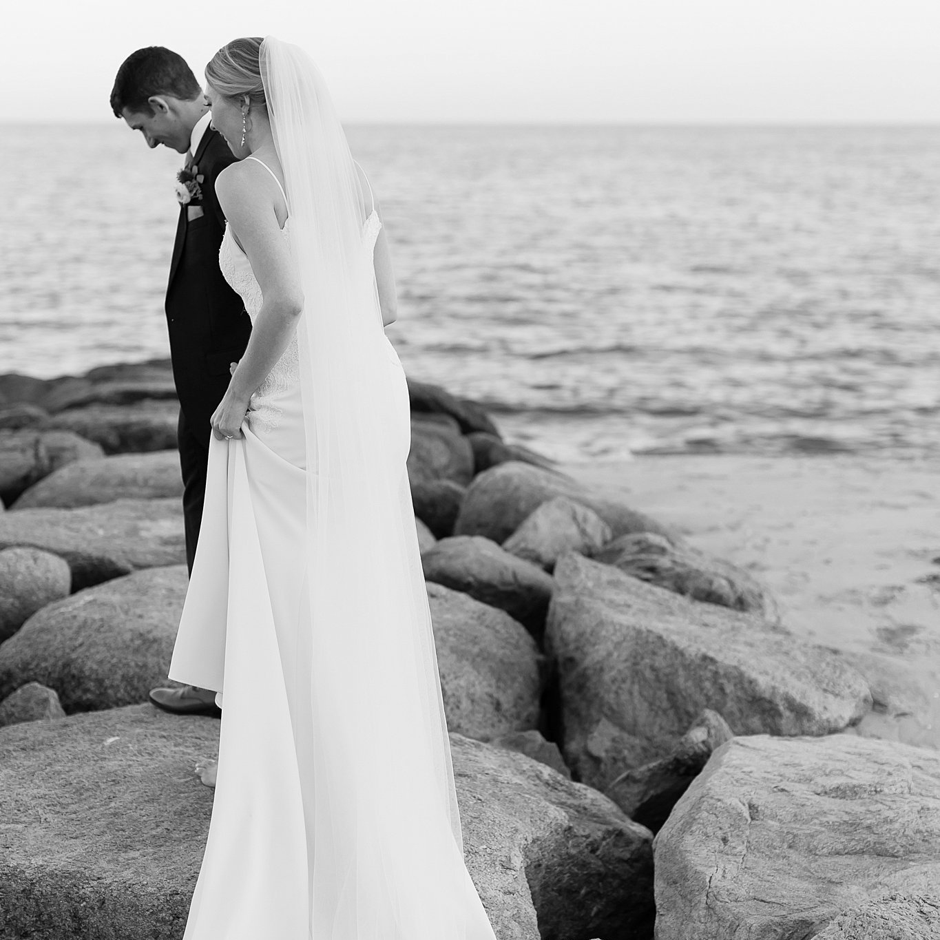 Couple walk on a rock jetty during their wedding at the Pelham House. Deborah Zoe Photography.