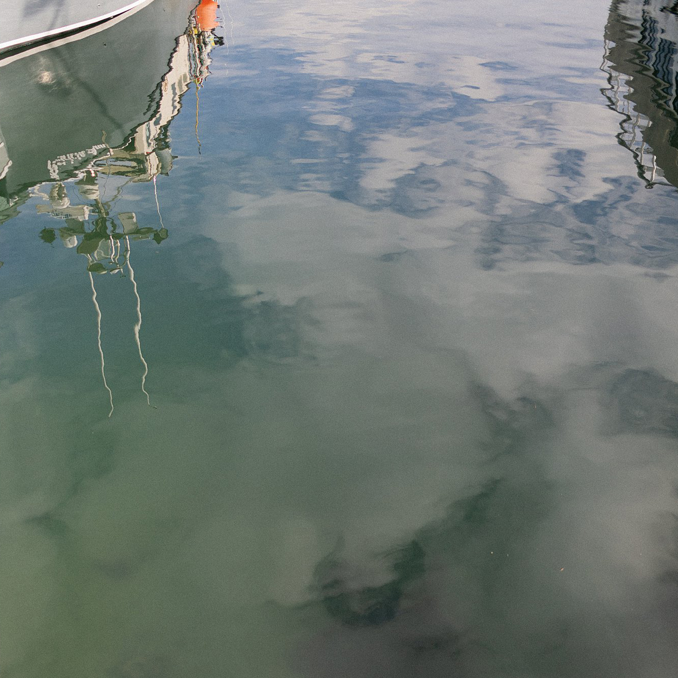 Boat reflects in water in Portland, Maine. Deborah Zoe Photography.