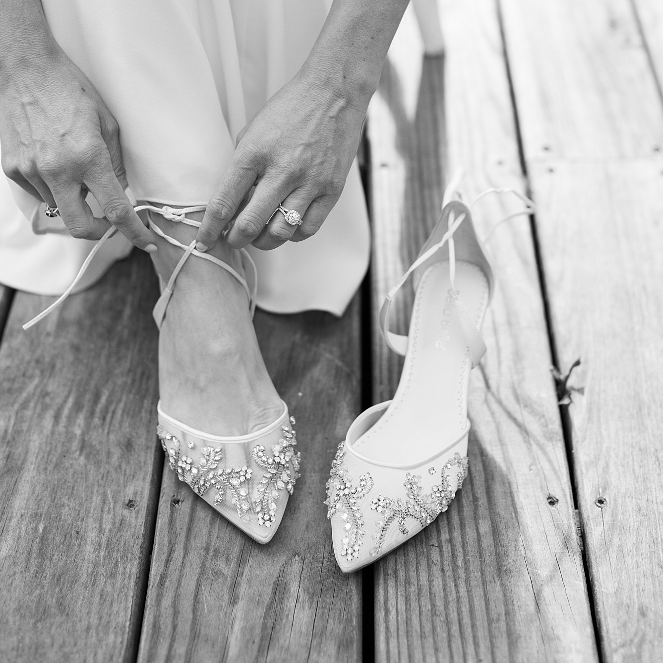 Bride adjusts strap on her Bella Belle shoes in her wedding gown.