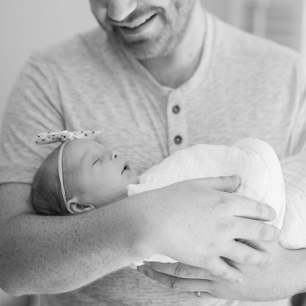 Father holds swaddled newborn in his arm. Boston Newborn Photography Deborah Zoe Photography