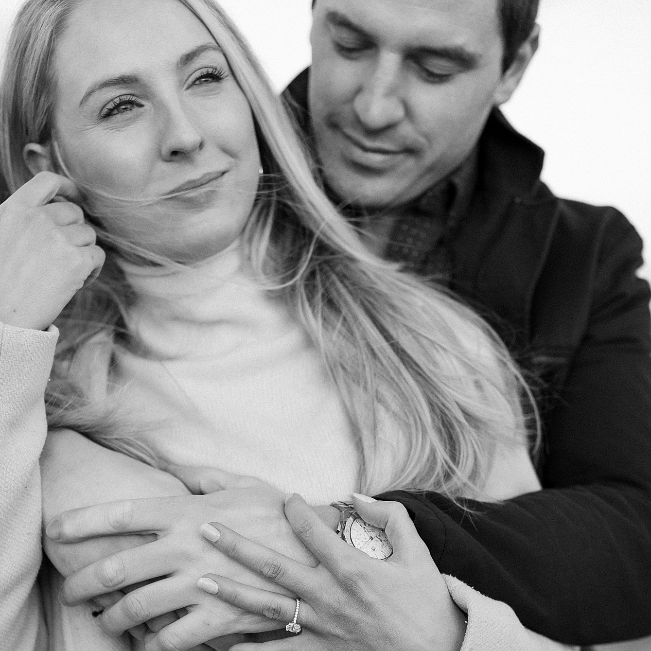 Couple embrace as women's hair blows in the wind during engagement session. Deborah Zoe Photography