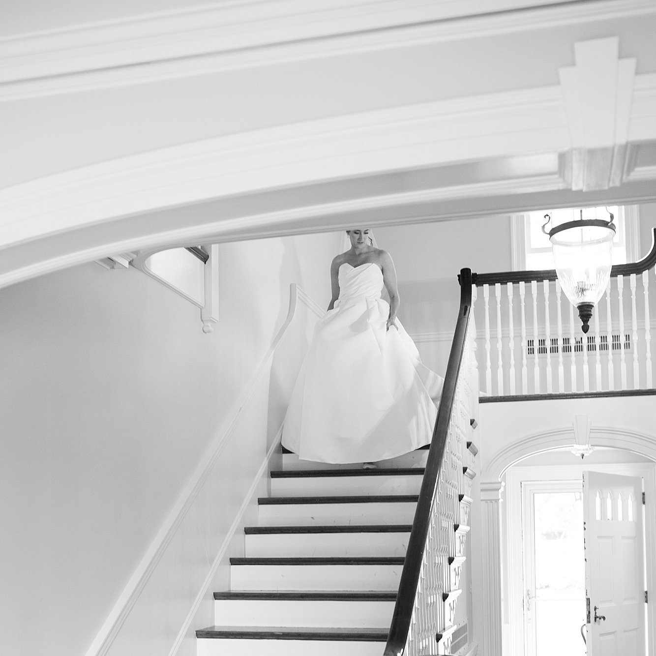 Bride walks down staircase of Connemara House in her wedding dress. Topsfield. Deborah Zoe Photography.