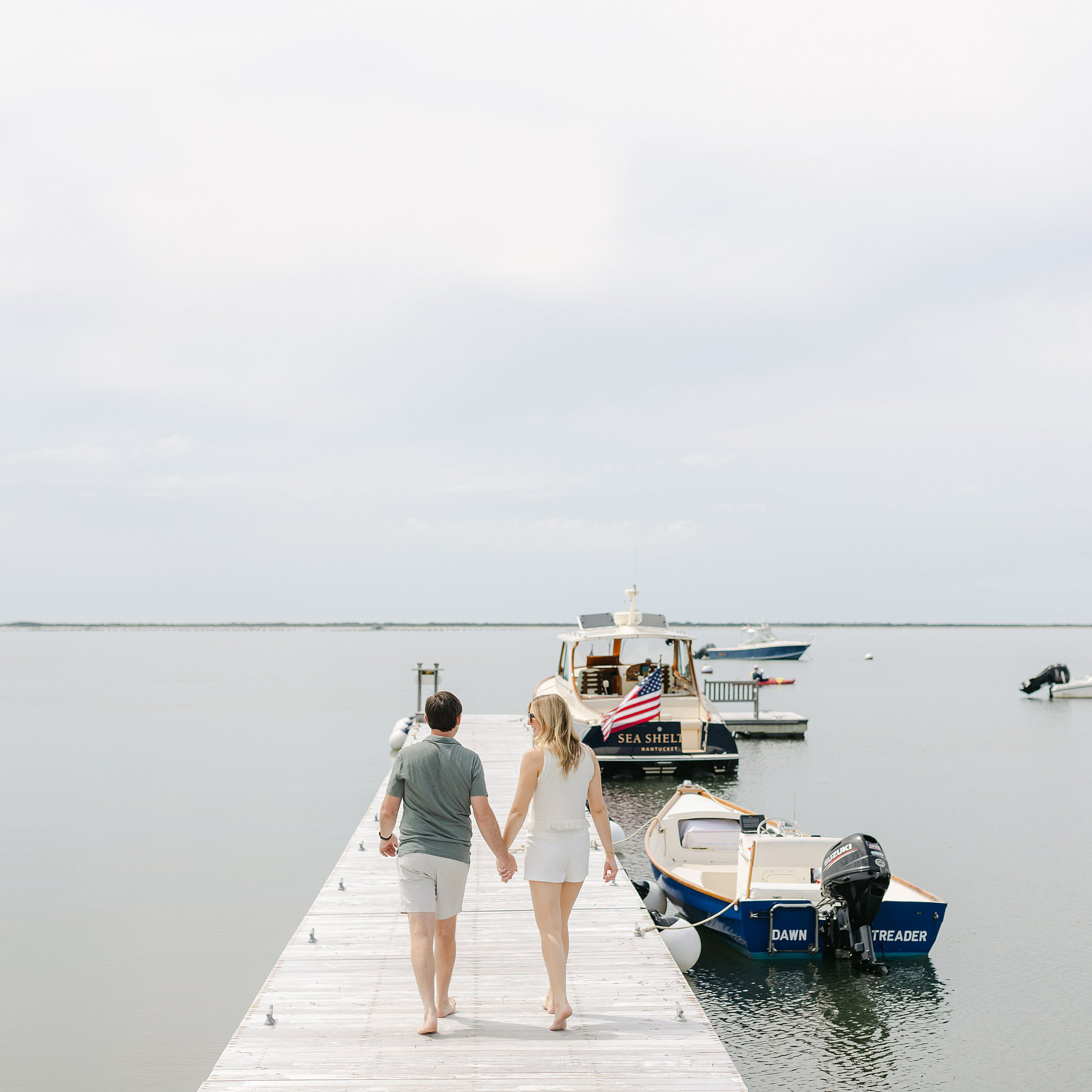 Couple walk hand in hand on dock at Wauwinet. Deborah Zoe Photography.