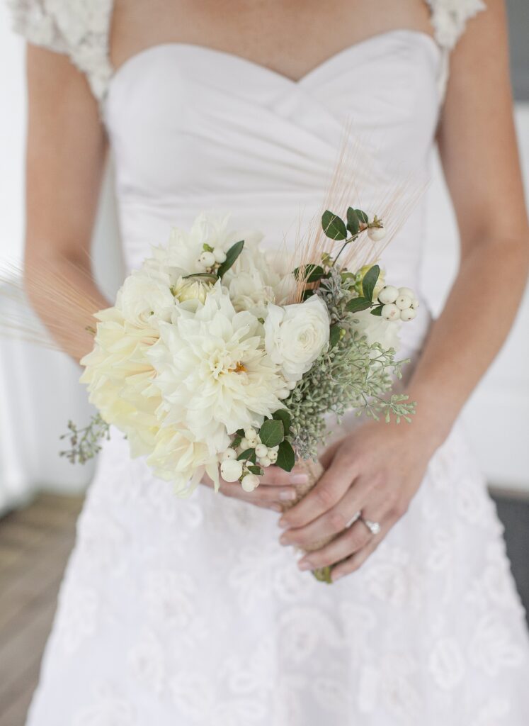 Bride holds a bouquet of cream and yellow flowers. Vermont Wedding Photographer Deborah Zoe Photography