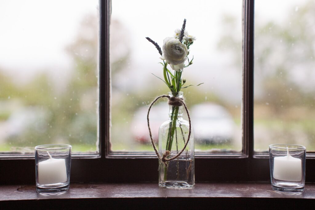 Detail of vase with candles in front of a window. Vermont Wedding Photographer Deborah Zoe Photography