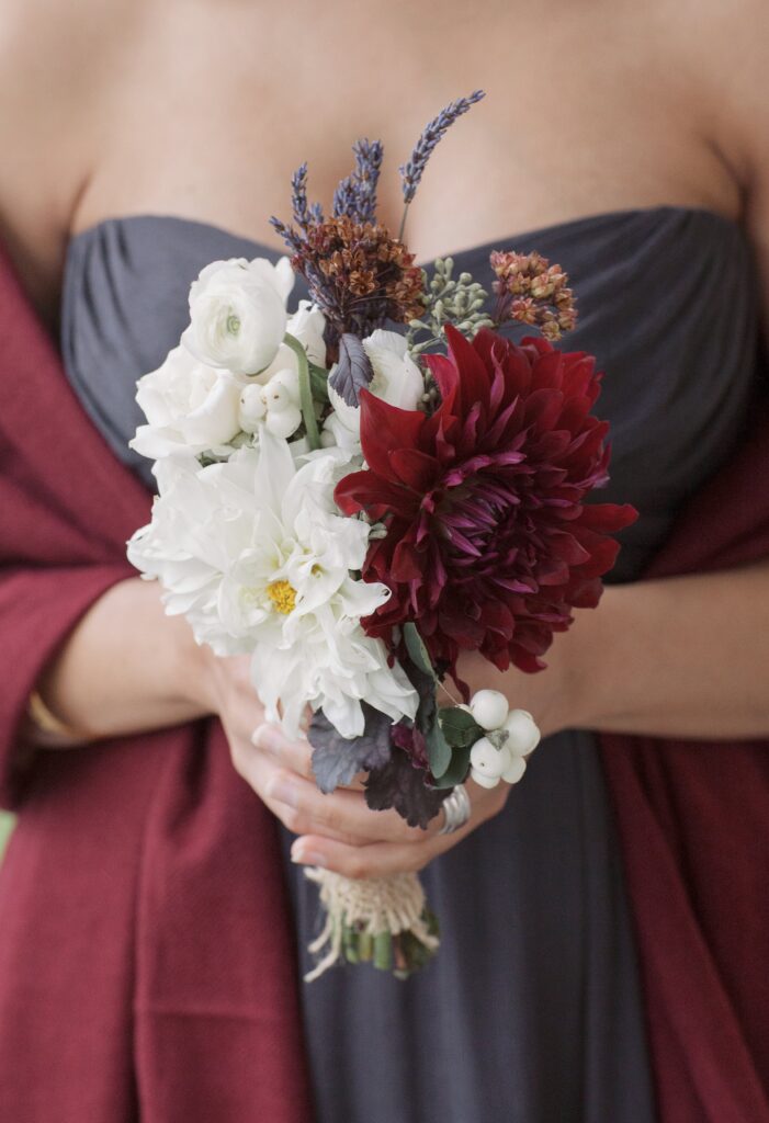 Close up detail of a bridesmaid bouquet in front of grey dress. Vermont Wedding Photographer Deborah Zoe Photography