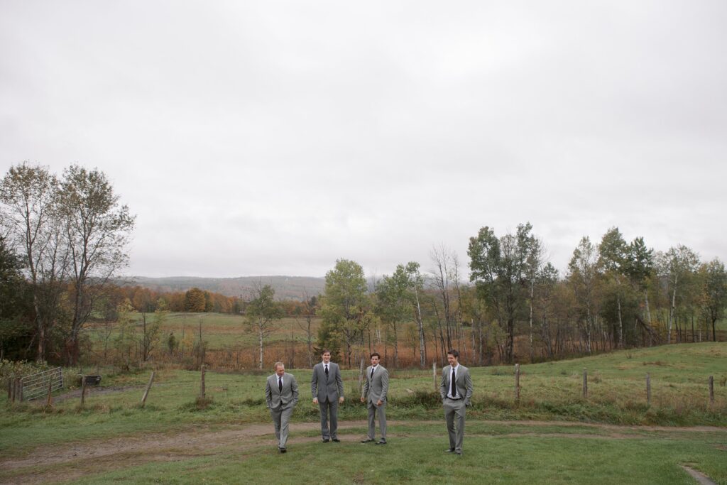 Groomsmen walk in grey suits towards camera during Vermont wedding. Vermont Wedding Photographer Deborah Zoe Photography