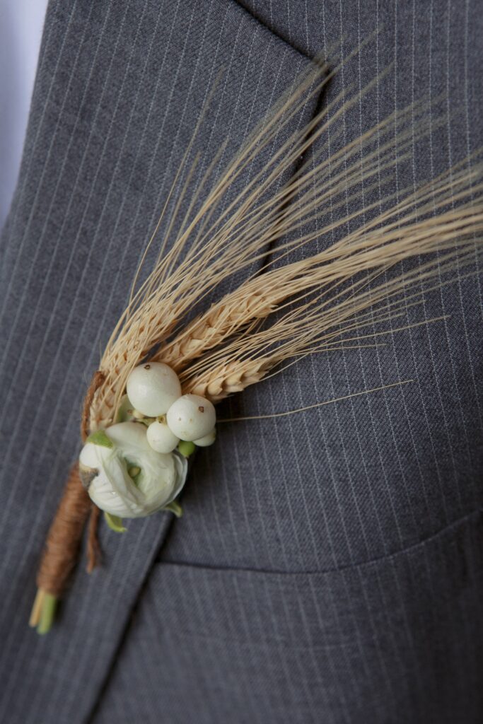 Close up detail of boutonniere against grey suit. Vermont Wedding Photographer Deborah Zoe Photography