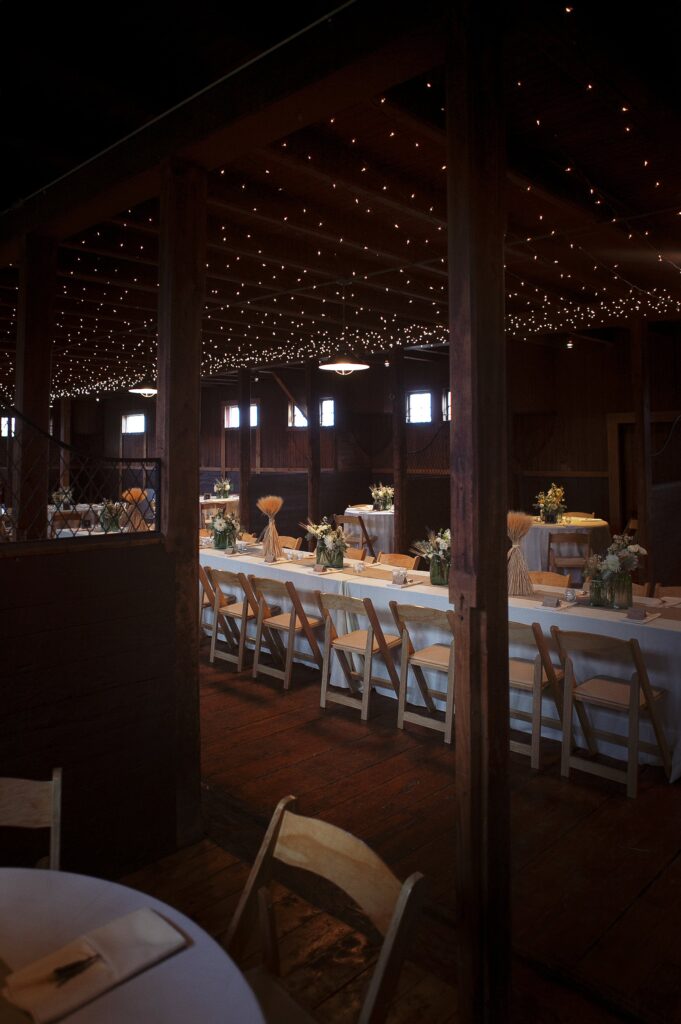 Dinner reception decor in horse barn. Vermont Wedding Photographer Deborah Zoe Photography