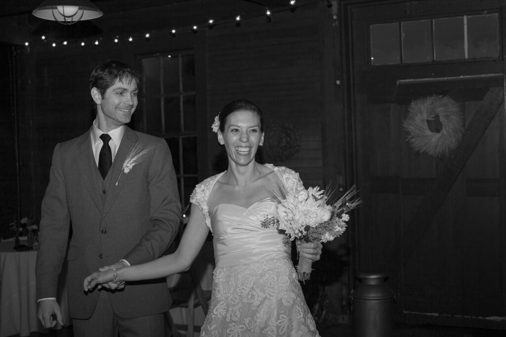 Bride and Groom smile as they enter their wedding reception. Vermont Wedding Photographer Deborah Zoe Photography