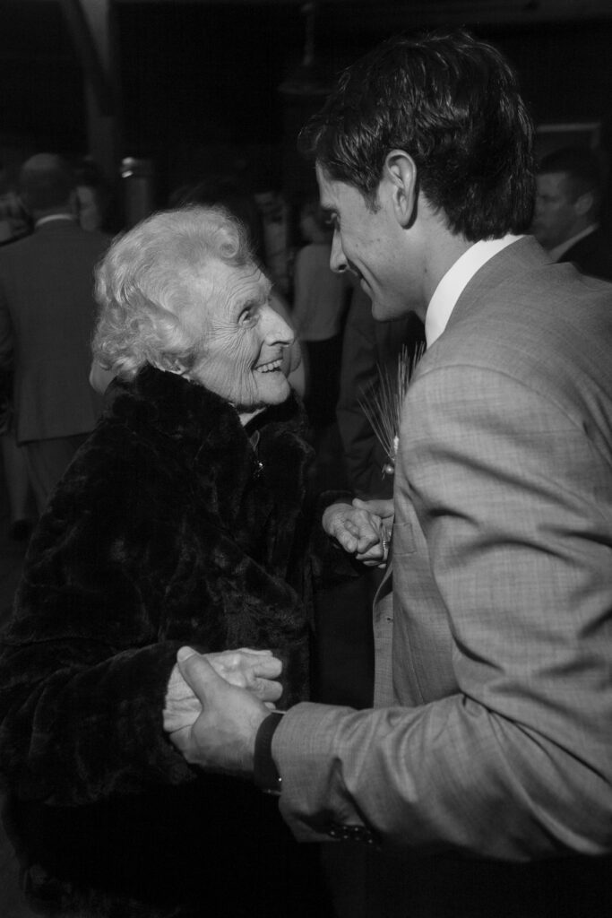 Older woman dances with grandson during wedding reception. Vermont Wedding Photographer Deborah Zoe Photography