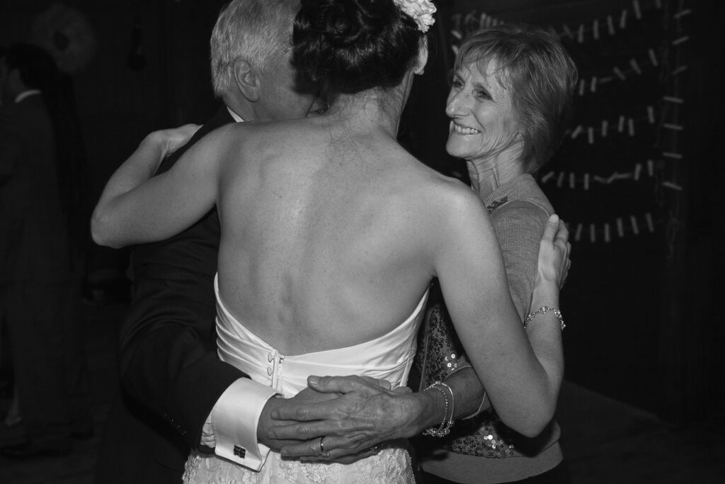 Bride dances with parents and smiles during wedding reception. Vermont Wedding Photographer Deborah Zoe Photography