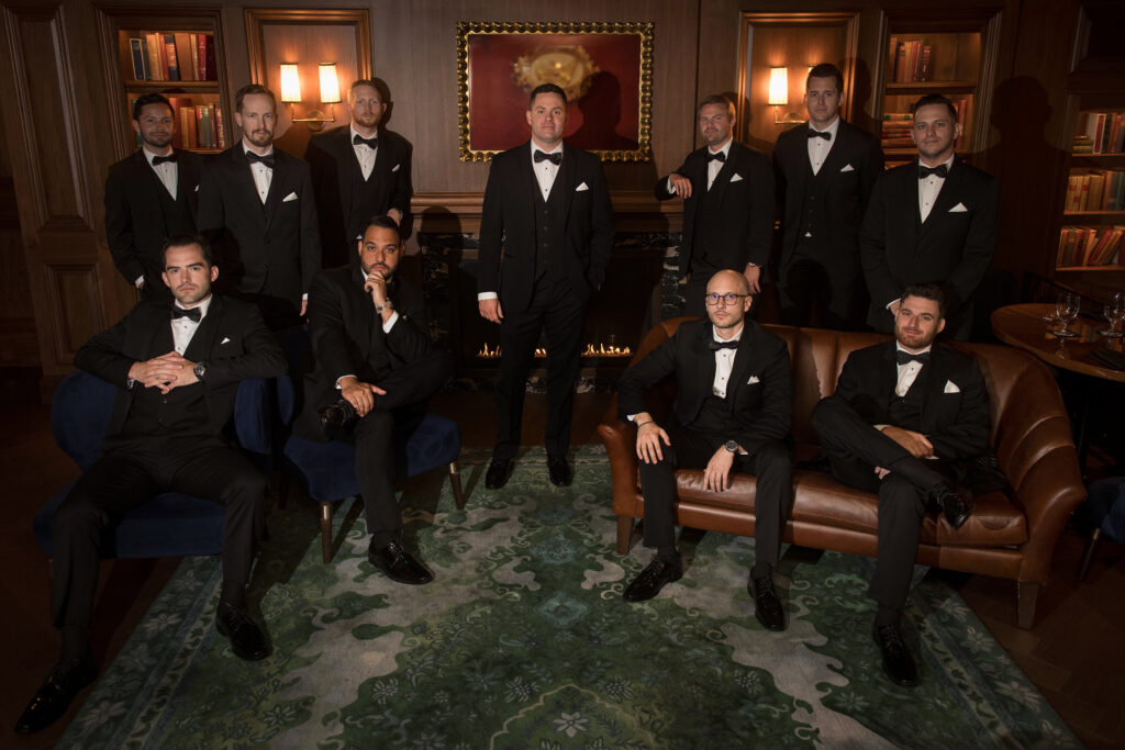 Groom poses with his groomsmen in lobby of the Newbury Hotel Boston. Modern Summer Wedding at the Newbury Boston Hotel photographed by Deborah Zoe Photography. 