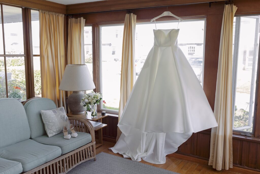 Wedding dress hanging in the window. Coastal New England Wedding.