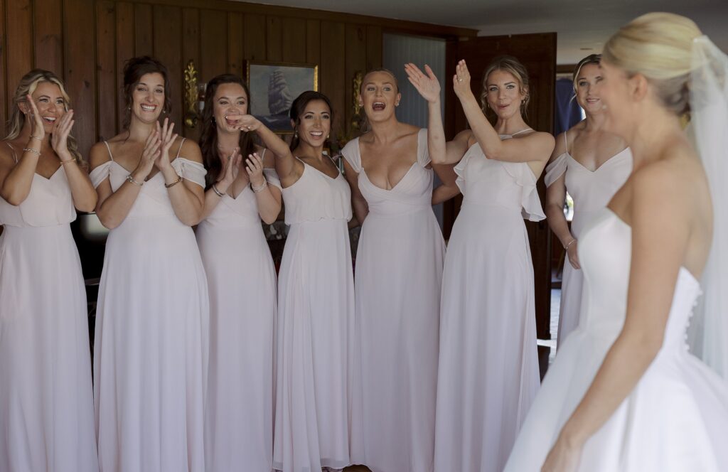 Bridesmaid react joyfully to seeing Bride in her wedding dress. Coastal New England Wedding.