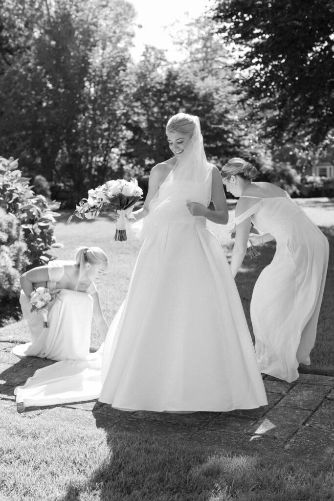 Bridesmaids adjust Bride's dress. Coastal New England Wedding.