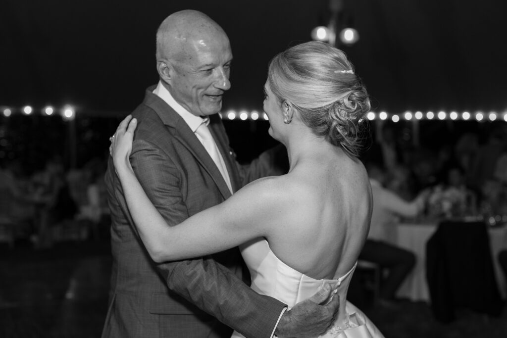 Father looks lovingly towards his daughter as they dance together during wedding reception. Coastal New England Wedding.