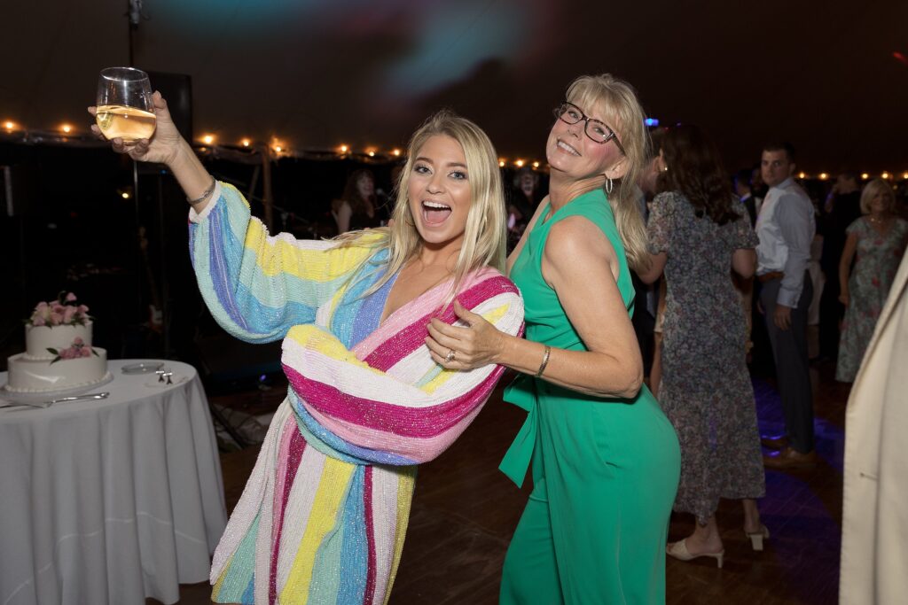 Guests celebrate and dance on the dancefloor during tented wedding reception. Coastal New England Wedding.