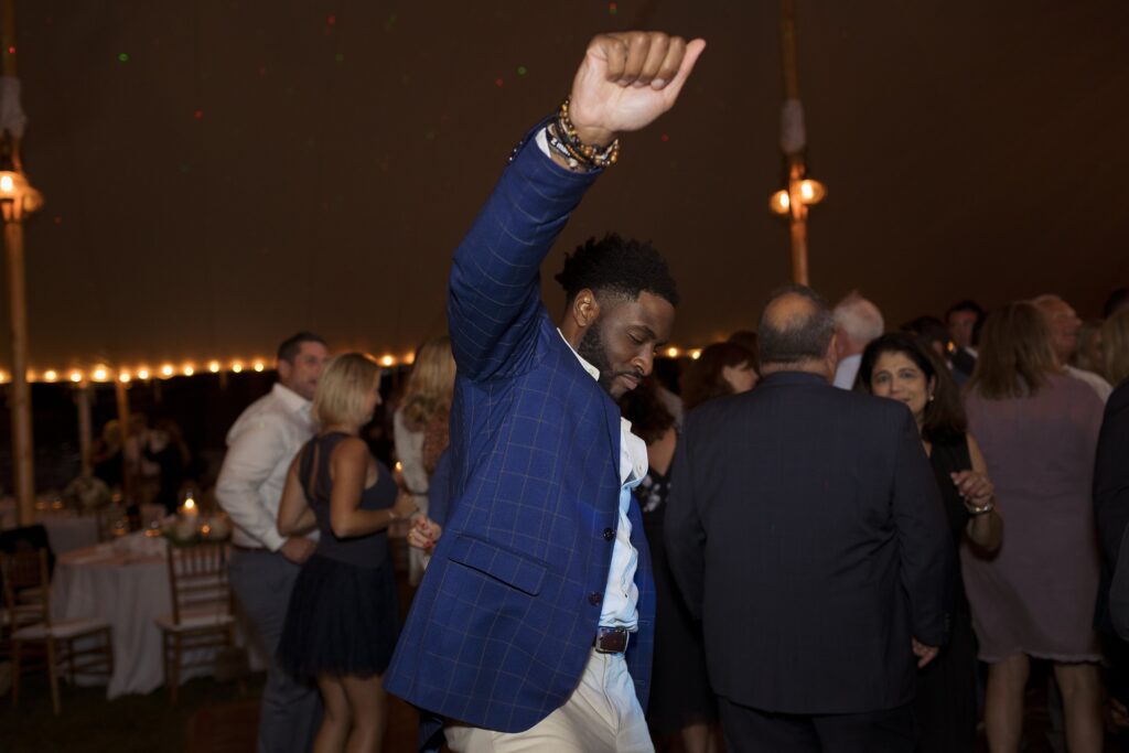 Guests celebrate and dance on the dancefloor during tented wedding reception. Coastal New England Wedding.