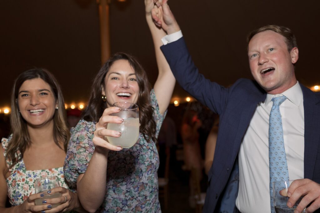 Guests celebrate and dance on the dancefloor during tented wedding reception. Coastal New England Wedding.