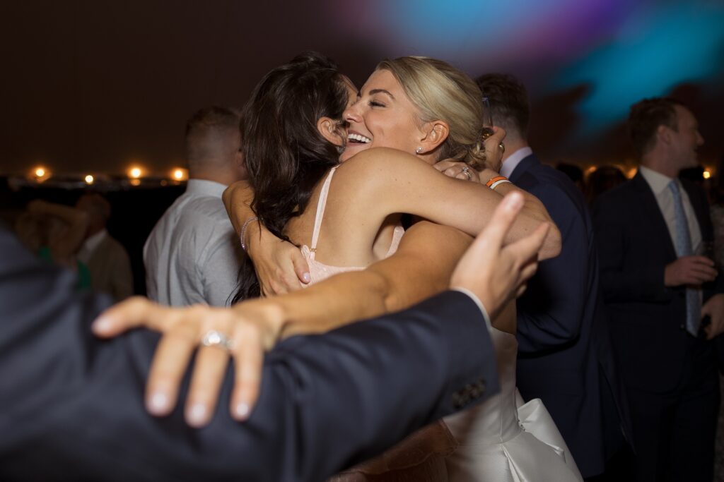 Guests celebrate and dance on the dancefloor during tented wedding reception. Coastal New England Wedding.