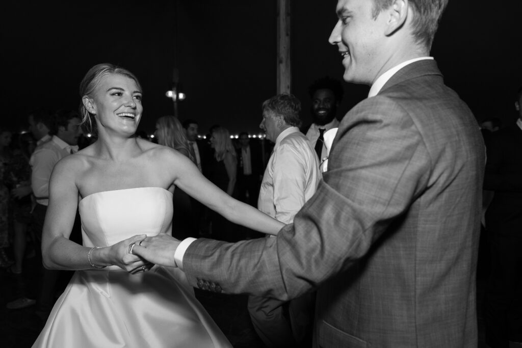 Bride and Groom celebrate and dance on the dancefloor during tented wedding reception. Coastal New England Wedding.