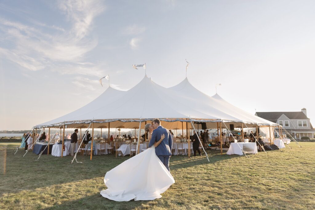 Bride and Groom kiss in front of Sperry tent. Coastal New England Wedding.