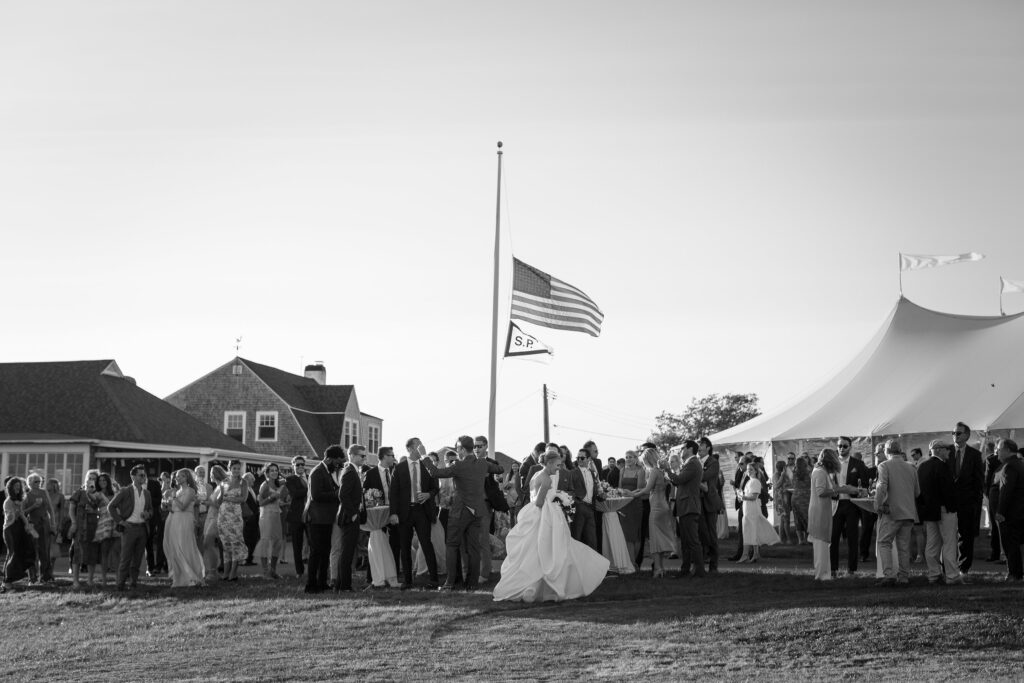 Wedding guests gather outside in front of the reception tent. Coastal New England Wedding.